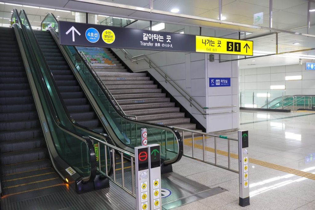 경기도 안산 서해선 초지역 갈아타는 곳의 에스컬레이터 두 대와 옆 계단, 입구 기둥에 붙은 안전수칙 그림 표지