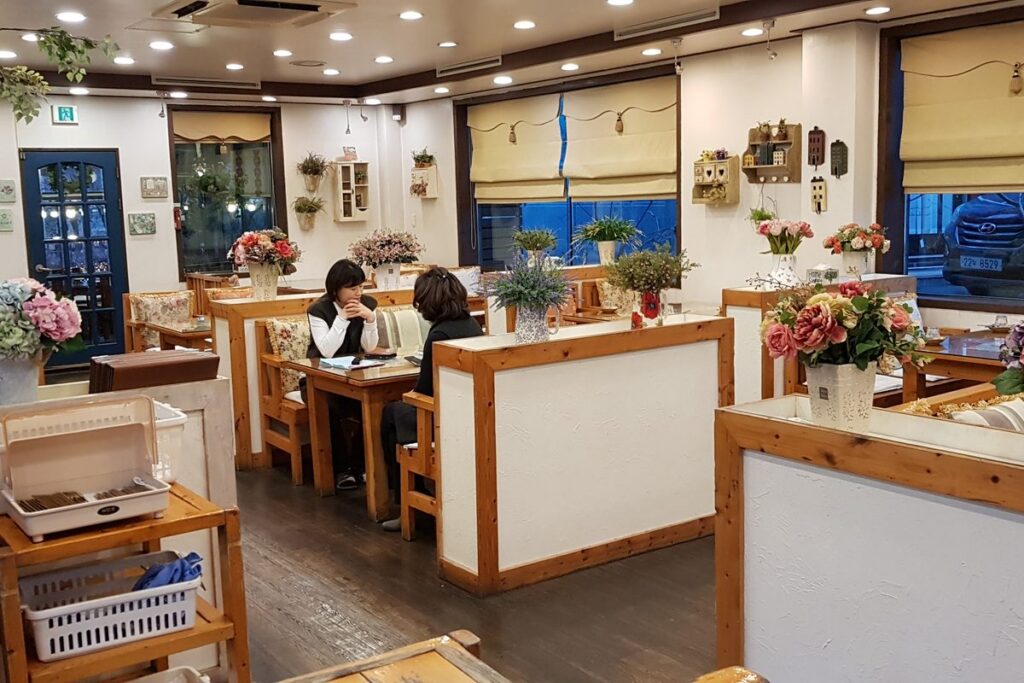 꽃 장식과 칸막이로 나뉜 테이블이 놓인 경기도 용인의 한 식당 내부
